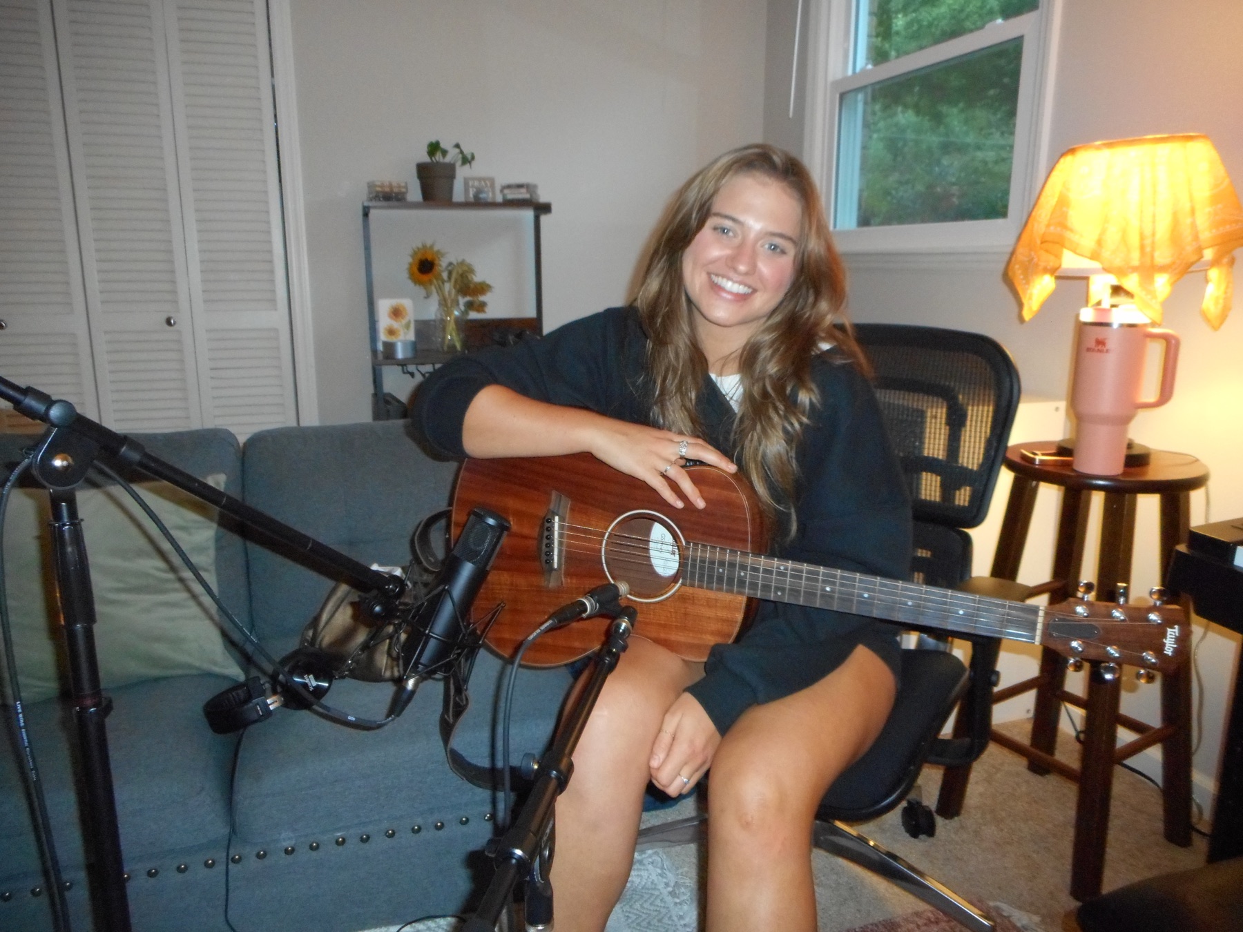 An artist tracking acoustic guitar in the studio