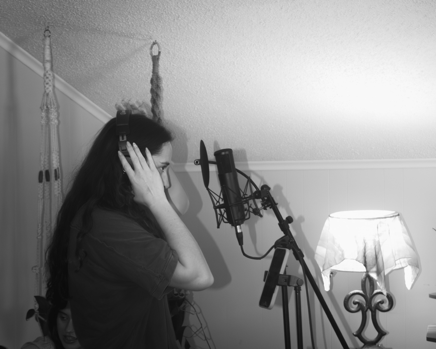 An artist putting on headphones at the vocal mic